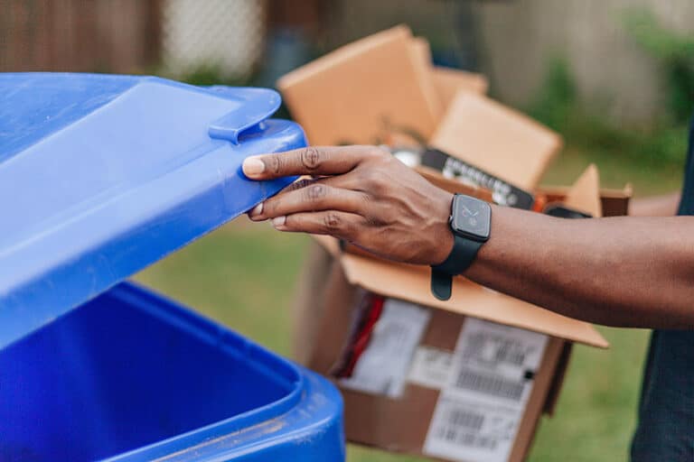 Man placing cardboard in recycling bin